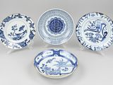 four blue and white plates with designs of birds and flowers on them
