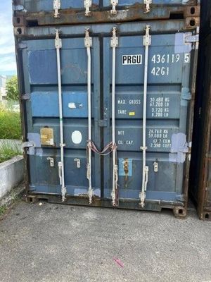 a blue shipping container sitting on the side of the road