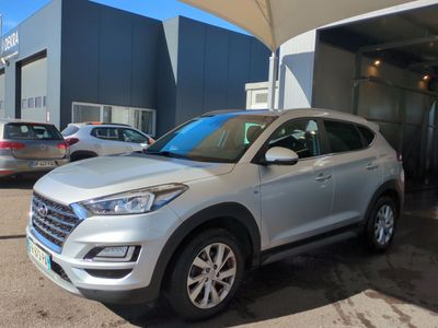 un SUV argenté garé devant un immeuble, à côté d'un parking