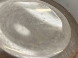 a close up view of a glass vase with a brown rim