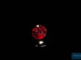 a close up of a red diamond on a black surface