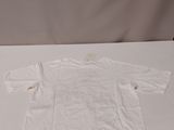 a white shirt sitting on a table with a cell phone next to it