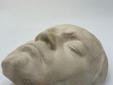 a white sculpture of a man ' s face on a white surface