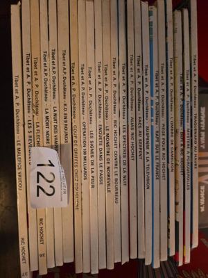 a lot of books that are stacked up on a shelf