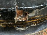 a close up of a black vase with a hole in it