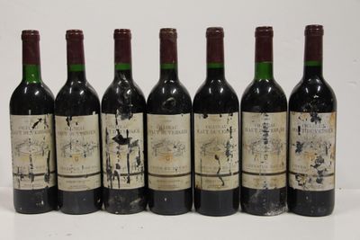 six bottles of wine are lined up in a row on a white surface