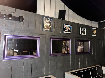 une pièce avec des tableaux accrochés au mur et un canapé devant