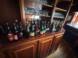 many bottles and glasses on the bar in the room