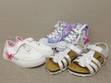 three pairs of children ' s shoes sitting on the floor