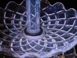 a glass cake stand with a candle on it