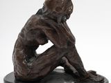 bronze sculpture of a monkey sitting on a black base