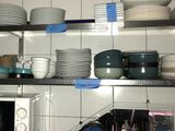 beaucoup d'assiettes et de bols sur les étagères de la cuisine