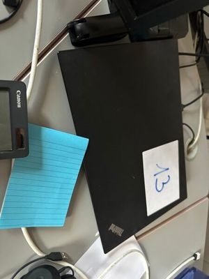 une photo d'un bureau encombré avec un ordinateur et un bloc-notes