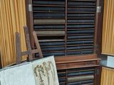 a wooden easel with a painting on it in front of a window