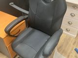 a black office chair sitting next to a wooden desk