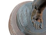a bronze statue of a person with a foot on a pedestal
