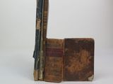 two old books stacked on top of each other on a table