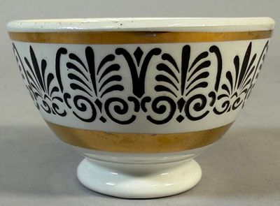 a black and white bowl with gold trim on it