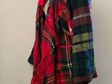 a red and black plaid jacket on a mannequin stand