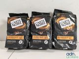 three bags of coffee sitting on top of a counter top