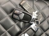 two car keys sitting on top of a black leather seat