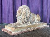 une statue représentant un lion assis sur une table