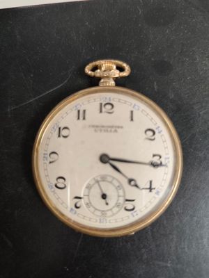 a gold pocket watch sitting on top of a black table