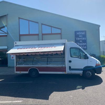 un petit food truck garé devant un immeuble