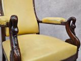 a yellow leather chair with a carved arm and foot rest