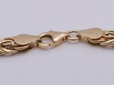 a gold chain bracelet on a white background