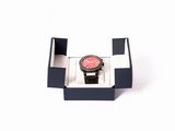 une montre posée dans un coffret sur une surface blanche
