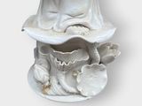 a statue of a woman sitting on top of a flower pot