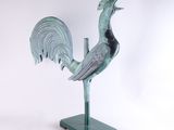 statue of a rooster on a green base on a white background