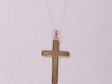 a gold cross necklace with a chain on a white background