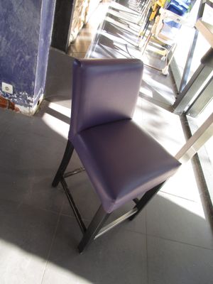 une chaise violette qui se trouve à côté d'une chaise bleue
