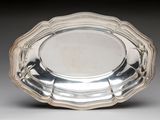 silver plate with scalloped edge on grey background