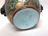 a blue and gold vase sitting on a white surface