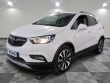 un SUV Buick blanc garé sur un sol à damier dans un garage