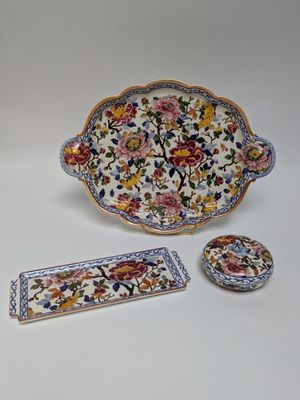 three pieces of pottery sitting on a white surface
