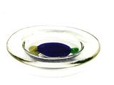 une pilule bleue et verte dans un bol en verre posé sur une surface blanche