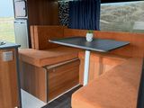 an image of a camper with a kitchen and dining area