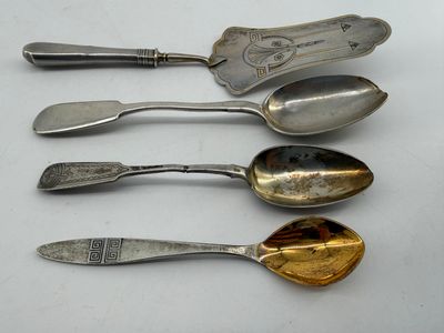 four spoons and a spoon rest on a white surface