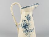 blue and white pitcher with a floral design on it