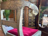 a wooden chair with a red cushion in a room