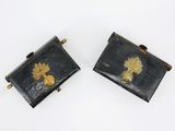 paire de boutons de manchette en métal noir et doré, ornés d'un motif de feuille