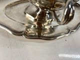a silver plate with a bowl on it on a table