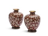 une paire de vases rouges et blancs posés sur une surface blanche