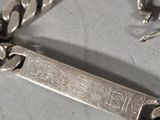 a silver bracelet that has a silver tag on it