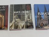 des livres posés sur une table blanche recouverte d'une nappe blanche, sur fond blanc