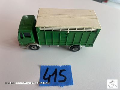 un petit camion jouet vert avec une caisse à l'arrière